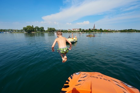 Kind beim Sprung ins Wasser vom Tretboot vor Radolfzell